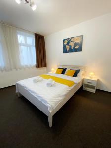 a bedroom with a large bed with yellow and blue pillows at Central Park House in Cluj-Napoca