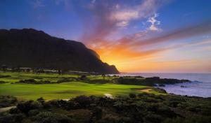 una puesta de sol sobre un campo de golf con el océano en Bienestar Buenavista by Vive La Exclusividad en Buenavista del Norte
