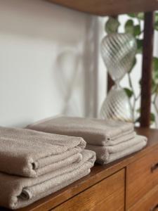 a pile of towels on a wooden dresser with a mirror at Studio Senang in Nijmegen +32 photos