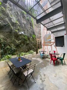 een patio met een tafel en stoelen en een televisie bij Amazigh Hostel & Suites in Aljezur