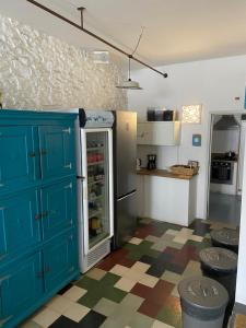 a kitchen with a blue cabinet and a refrigerator at AMAZIGH HOSTEL Ensuite Rooms & Dorms with shared Kitchen in Aljezur
