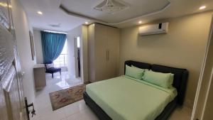 a bedroom with a bed with green sheets and a chair at C Suites in Lahore