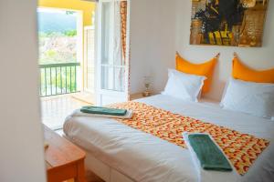 a bedroom with a large bed with an open window at Moby Dick Lodge Colares in Colares