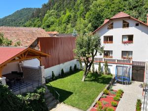 Blick auf ein Haus mit Garten in der Unterkunft Schei Residence in Braşov
