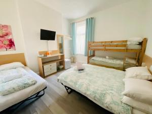 un dormitorio con dos camas y una litera en Granville Hotel, en Blackpool