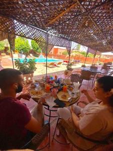 a group of people sitting at a table eating food at La Kasbah du Jardin in Aït Benhaddou