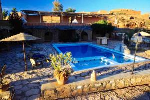 a swimming pool in a yard with a house at La Kasbah du Jardin in Aït Benhaddou