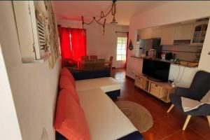 uma sala de estar com um sofá e uma cozinha em Vila T2 Algarve piscina privada em Vila Nova de Cacela