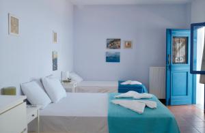 a white room with a bed and a blue door at Alia's sea view villa & studios in Apróvaton