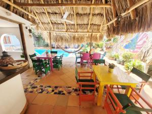 ein Restaurant mit Tischen und Stühlen und einem Pool in der Unterkunft Divanga Hostel and Diving in Taganga