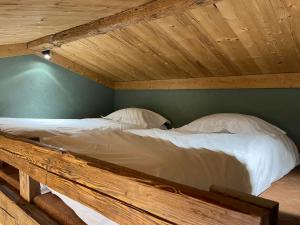 2 Betten in einem Schlafzimmer mit Holzdecke in der Unterkunft Nid douillet au cœur de Megeve in Megève