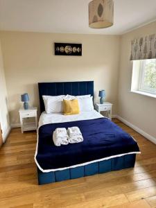 a bedroom with a blue bed with two towels on it at JB Stays Croydon Townhouse in South Norwood