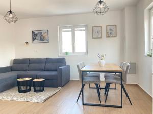 uma sala de estar com um sofá azul e uma mesa em Apartments Rising Sun, Ražanac em Ražanac