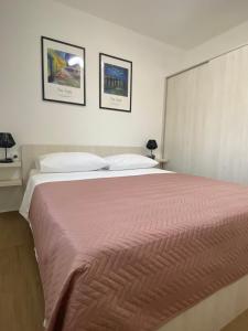 um quarto com uma cama grande e duas fotografias na parede em Apartments Rising Sun, Ražanac em Ražanac