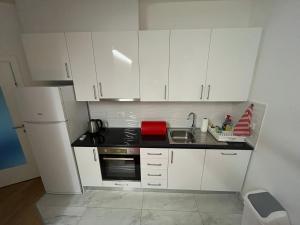 a small kitchen with white cabinets and a sink at Apartman Luca in Široki Brijeg