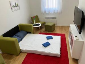 a living room with a bed and two chairs at Apartman Luca in Široki Brijeg