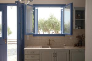 a bathroom with a sink and a window at Alia's sea view villa & studios in Apróvaton +41 photos