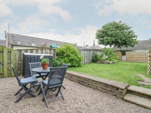 a patio with a table and chairs and a yard at Anchor Cottage in Elgin