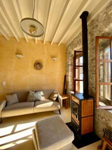 a living room with a couch and a wood stove at Monastery View House in Mandrakion