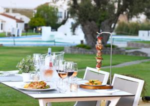 a table with plates of food and glasses of wine at Pedras D'el Rei in Tavira