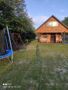 eine Scheune mit einer blauen Bank davor in der Unterkunft Domek Pod Sosnami in Tomaszów Lubelski