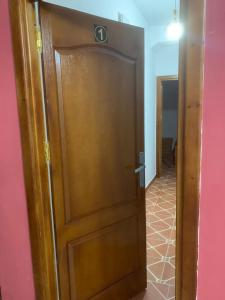 une porte en bois dans une chambre avec un mur rose dans l'établissement Appartement familial Al hoceima, à Al Hoceïma