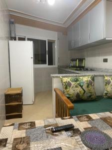 a kitchen with a couch and a refrigerator in a room at Appartement familial Al hoceima in Al Hoceïma