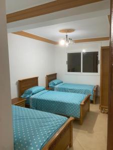 - 2 lits dans une chambre avec des draps bleus dans l'établissement Appartement familial Al hoceima, à Al Hoceïma