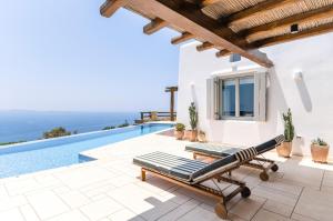 a villa with a swimming pool and a patio at Villa Olivia Mykonos in Agios Stefanos