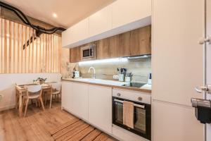 a kitchen with white cabinets and a table with a dining room at MyHouseSpain - Acogedor piso cerca de Atocha I in Madrid