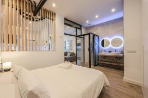 a bedroom with a large white bed and a bathroom at MyHouseSpain - Acogedor piso cerca de Atocha I in Madrid