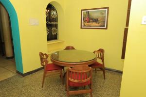 a dining room with a table and four chairs at Elite Heritage Stay in Puducherry