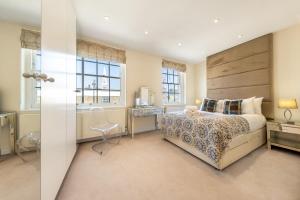 a bedroom with a bed and a desk and windows at Luxury 4 bed house in Belgravia Knightsbridge in London