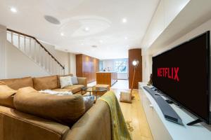 a living room with a couch and a large television at Luxury 4 bed house in Belgravia Knightsbridge in London