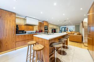 a kitchen with wooden cabinets and a bar with stools at Luxury 4 bed house in Belgravia Knightsbridge in London