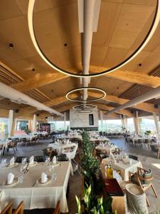 a restaurant with tables and chairs and a large chandelier at Agroturizëm Kodra e Kuajve in Durrës