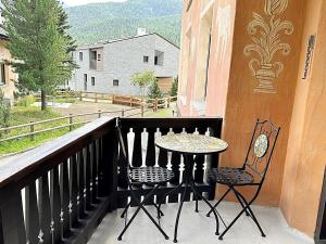 einen Tisch und zwei Stühle auf dem Balkon in der Unterkunft Natur, Erholung, moderne 35m2 für 2P mit Auto PP - SP19 in Pontresina
