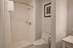 a white bathroom with a toilet and a shower at Four Points by Sheraton Peoria in Peoria