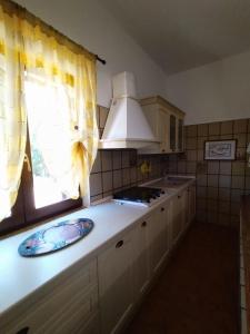 a kitchen with a sink and a window and a stove at Il Villino in Platamona