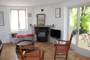 uma sala de estar com uma televisão e uma mesa e cadeiras em Les Vendangeurs, gîte au milieu des vignes face au Luberon em Goult