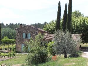 a stone house in a garden with trees at Les Vendangeurs, gîte au milieu des vignes face au Luberon in Goult