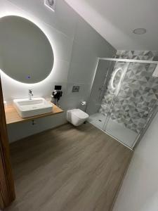 a bathroom with a sink and a toilet and a mirror at Casona de ventas in Portomarin