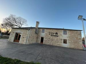 un edificio de ladrillo con un cartel en el costado en Casona de ventas, en Portomarín