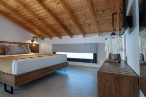 1 dormitorio con cama y techo de madera en Arroyo Suites Kalamitsi, en Kalamitsi