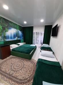 two beds in a room with a waterfall painting on the wall at Гостевой дом ЛОНТАНА in Gagra