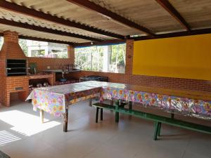 uma sala de jantar com uma mesa e dois bancos em Casa de Temporada Ceu e Mar em Praia do Bananal