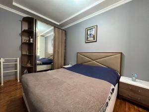 een slaapkamer met een bed en een grote spiegel bij Real Palace Apartments in Batoemi