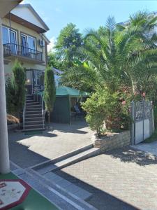 una casa con escaleras y una palmera delante de ella en Guest House Nino, en Makhinjauri