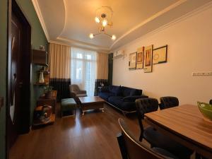 a living room with a blue couch and a table at Real Palace Apartments in Batumi