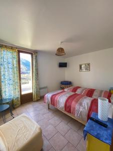 a bedroom with two beds and a large window at Ferme-auberge le cochon du Madres in Escouloubre